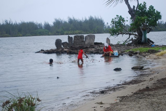 A mom and her children fish with a net near an ancient marea on Huahine in French Polynesia©Jean Janssen