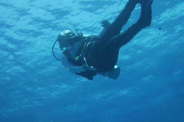 Natasha enters the water via a giant stride off the dive boat.  Turneffe Atoll, Belize. ©Bill Fugua