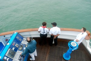 Officers on the Silver Wind Navigational Bridge which hangs out over each side of the ship to assist with docking.  Our captain is at the the controls, our pilot is in white, and the two other officers are the port pilots for East Durban. ©Jean Janssen 