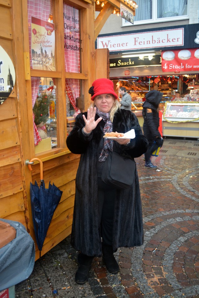 Natasha and her frankfurter in Frankfurt.  The red hat is the one I bought in Rothenburg. ©Jean Janssen